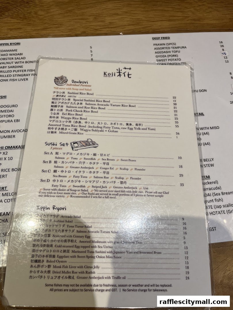 A menu from Koji Sushi Bar featuring Donburi, Sushi Sets, and Ippin Ryori dishes.