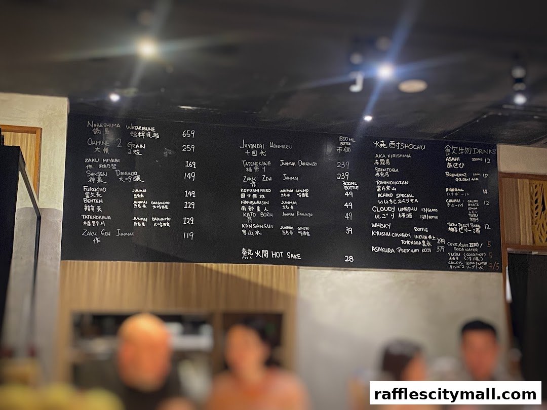 A close-up view of a Japanese restaurant's menu board, featuring various sake and shochu selections.