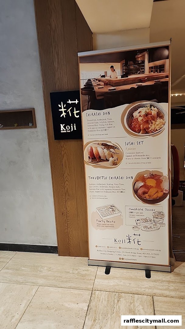A promotional stand for Koji Sushi Bar featuring various sushi and donburi dishes.