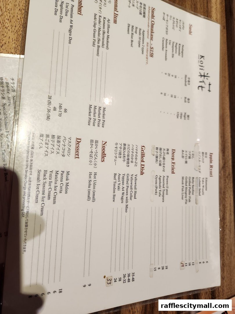 A menu from Koji Sushi Bar featuring sushi, appetizers, main courses, noodles, and desserts.