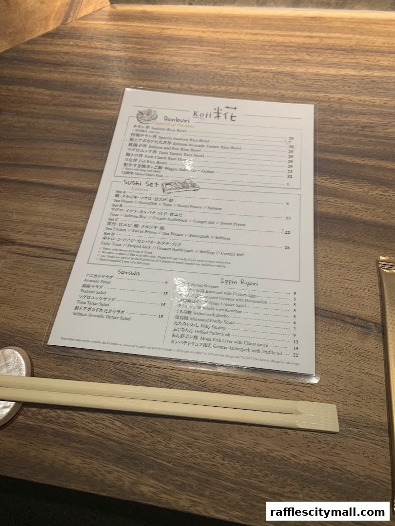 A menu from Koji Sushi Bar with various sushi sets, salads, and Japanese dishes.