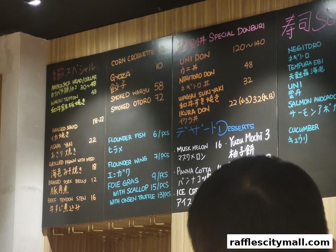 A close-up of a chalk menu board at Koji Sushi Bar, displaying various Japanese dishes and prices.