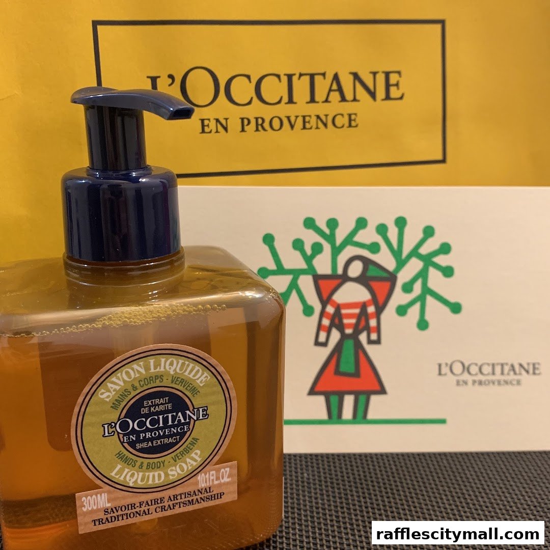 A bottle of L'Occitane liquid soap with a branded shopping bag and product packaging in the background.