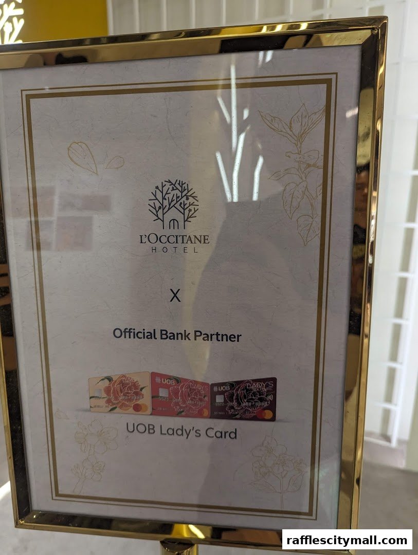 A framed sign announcing L'Occitane Hotel's partnership with UOB Lady's Card.