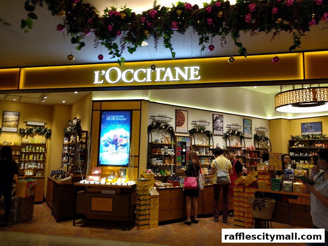 The L'Occitane store front displays a festive holiday theme with greenery and ornaments.