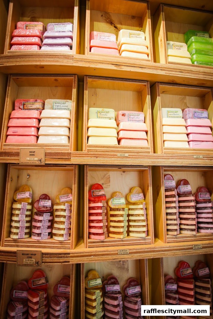 A display of colorful, handcrafted soaps in various shapes and scents on wooden shelves.