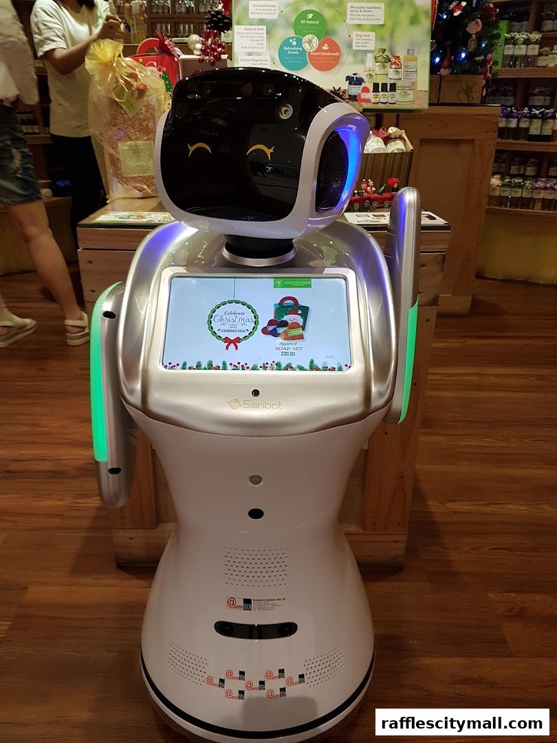 A robot with a screen displaying a Christmas promotion in a Lemongrass House store.