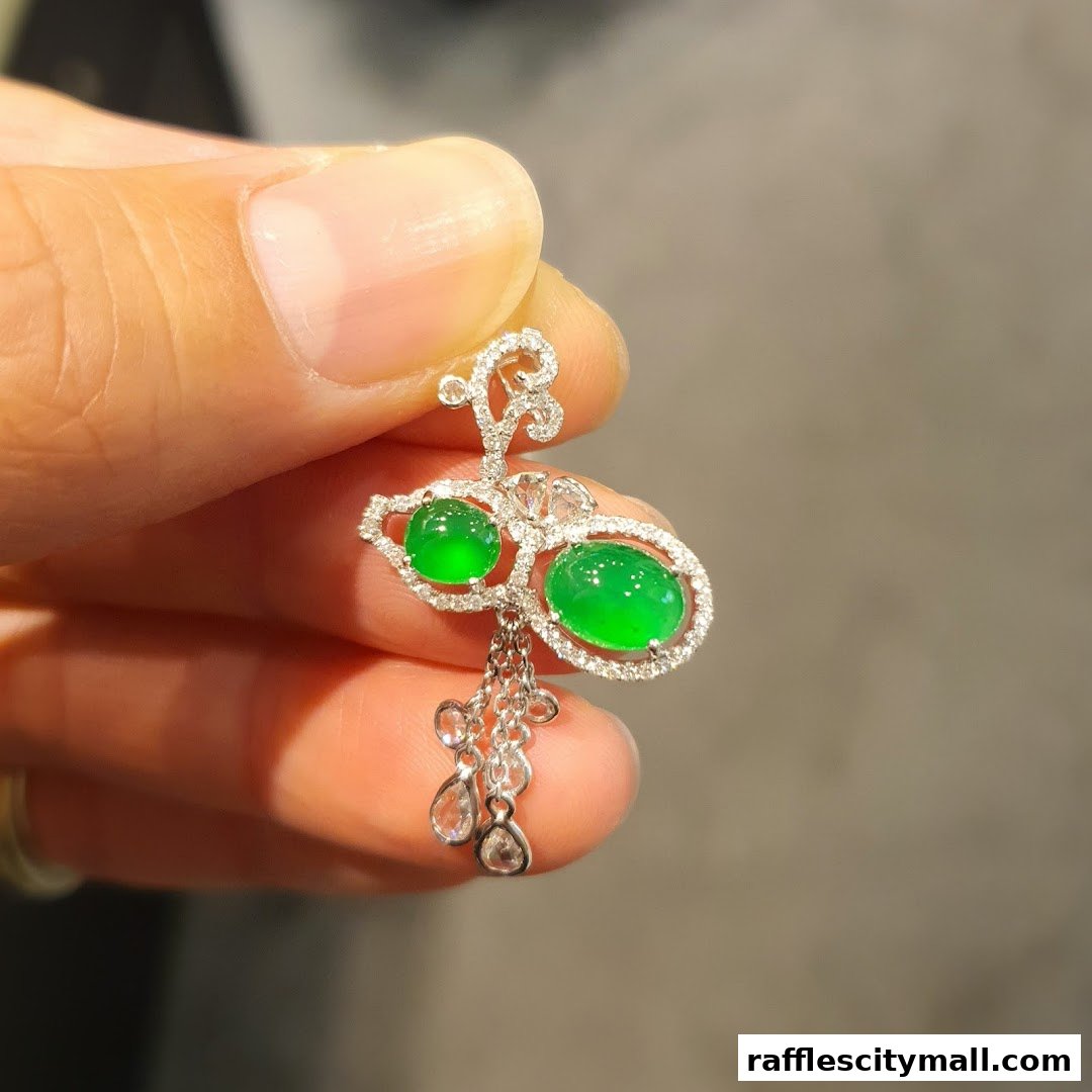 A hand holds a delicate jade and diamond pendant, showcasing exquisite craftsmanship.