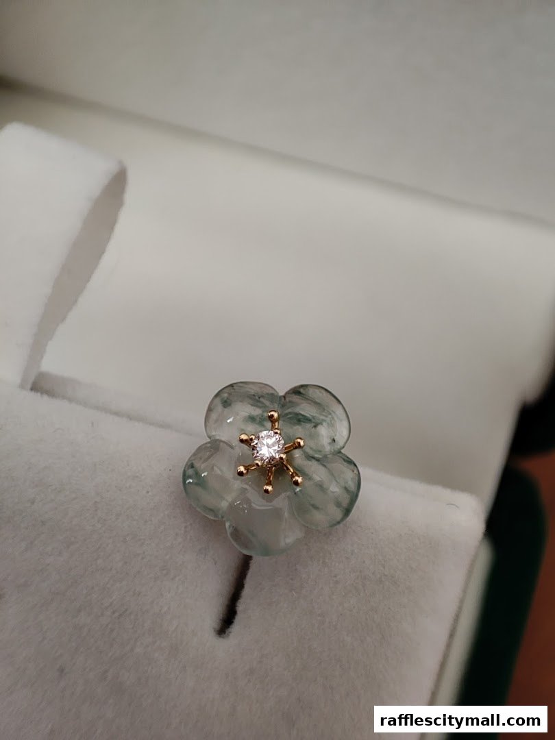 A close-up of a delicate jade flower pendant with a diamond center.