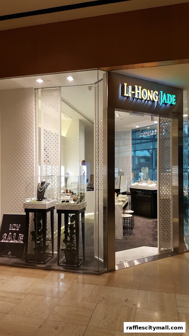 The exterior of a modern jewelry store, LI-HONG JADE, with illuminated signage and display cases.