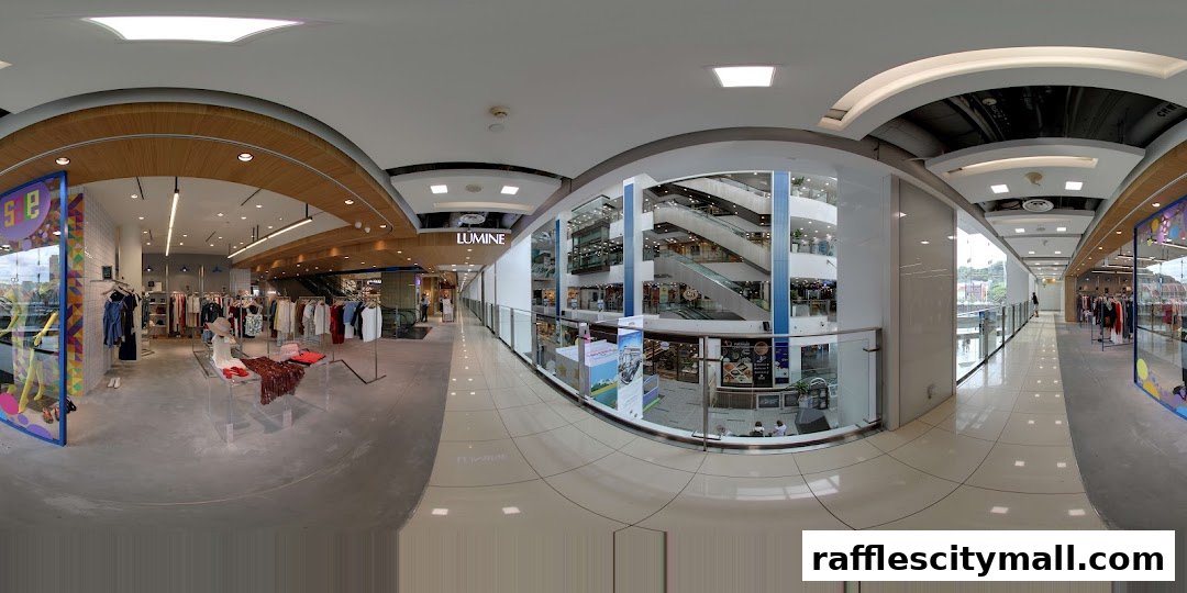 Interior view of a modern shopping mall with various retail stores and escalators.