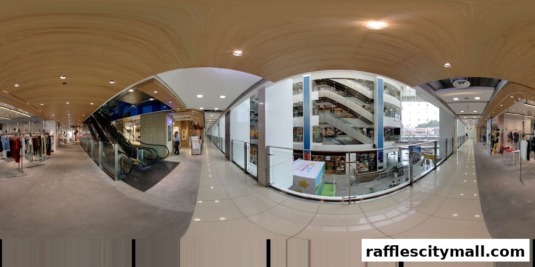 Interior view of a shopping mall with escalators, shops, and displays.
