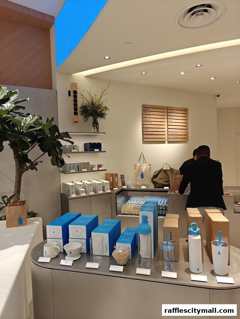 A modern coffee shop interior displaying branded merchandise and a menu board.