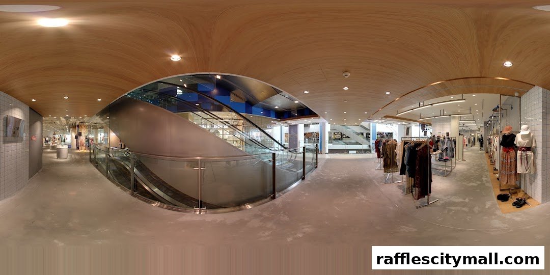 Interior view of a modern clothing store with escalators and displays of apparel.