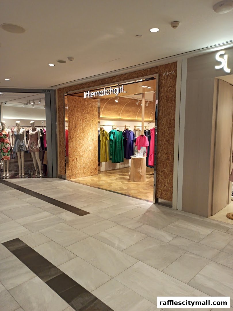 The entrance of a clothing store with mannequins and colorful dresses displayed inside.