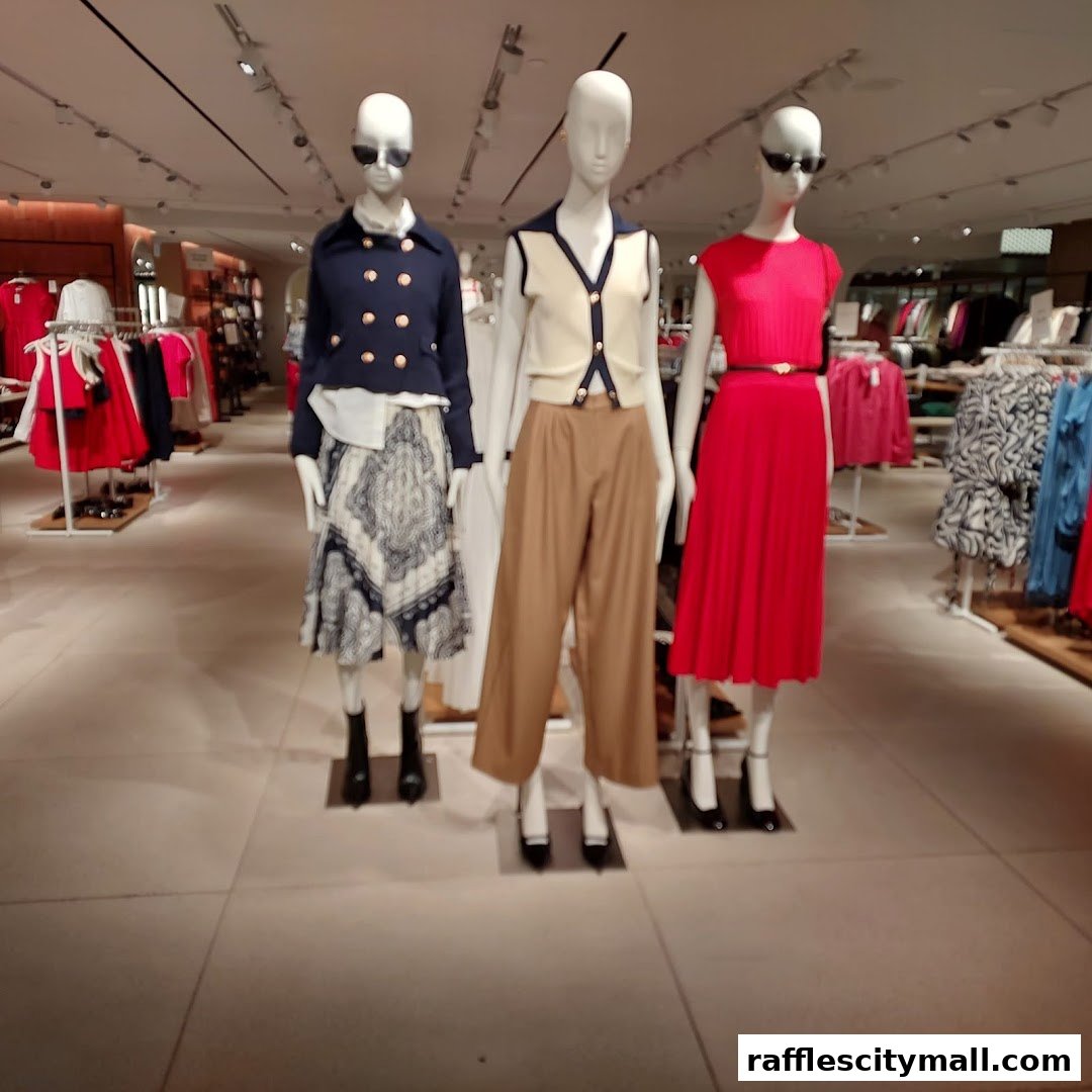 Mannequins display stylish outfits inside a well-lit clothing store.