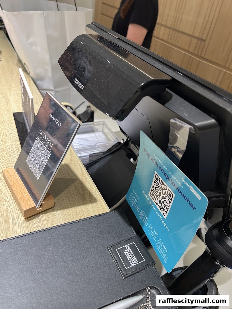 A retail counter with a POS system, QR codes for payment, and an American Express card holder.