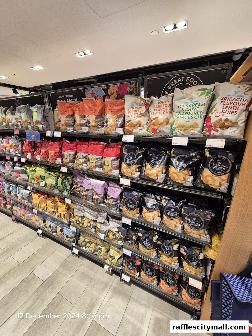 Shelves stocked with various bags of crisps and snacks at Marks & Spencer.