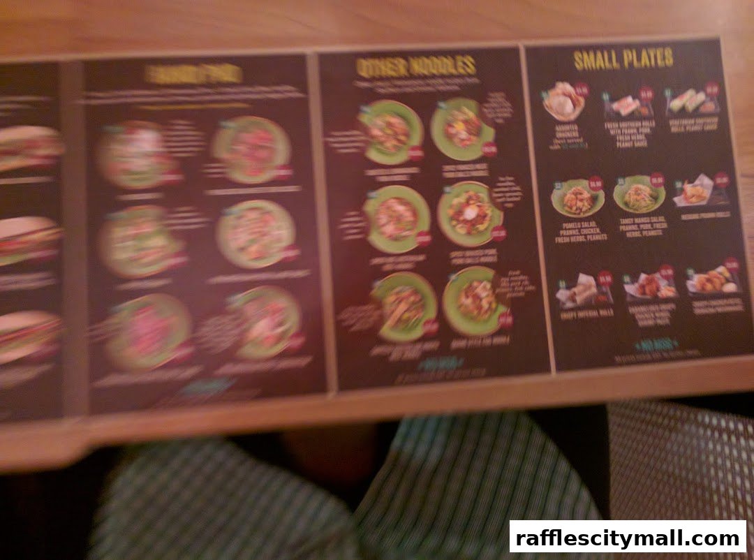 A menu board displaying various Vietnamese dishes including noodles and small plates.