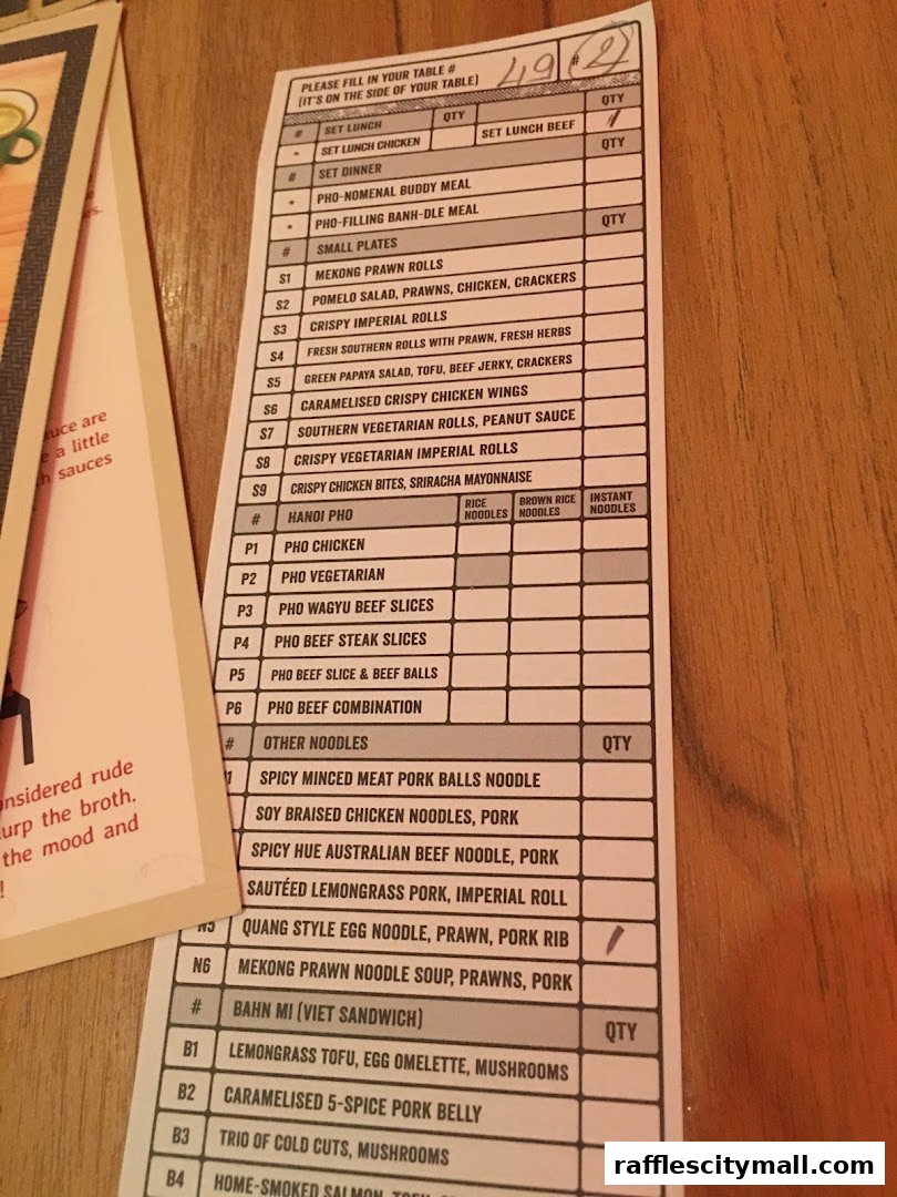 A close-up of a Vietnamese restaurant's order form with various pho and banh mi options.