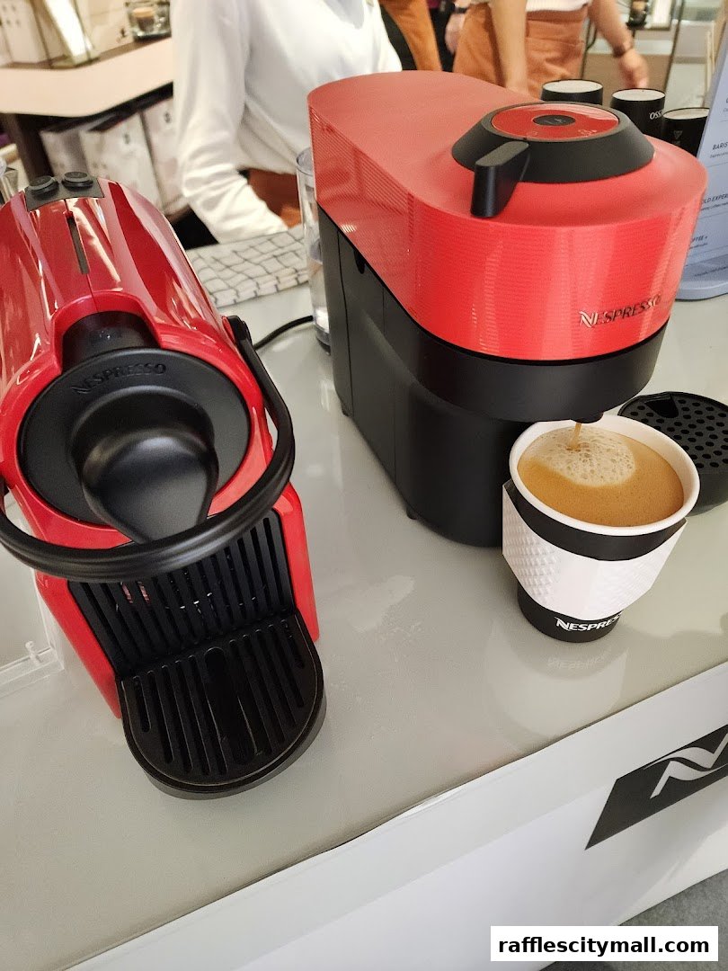 Two red Nespresso coffee machines are displayed, one brewing coffee into a cup.