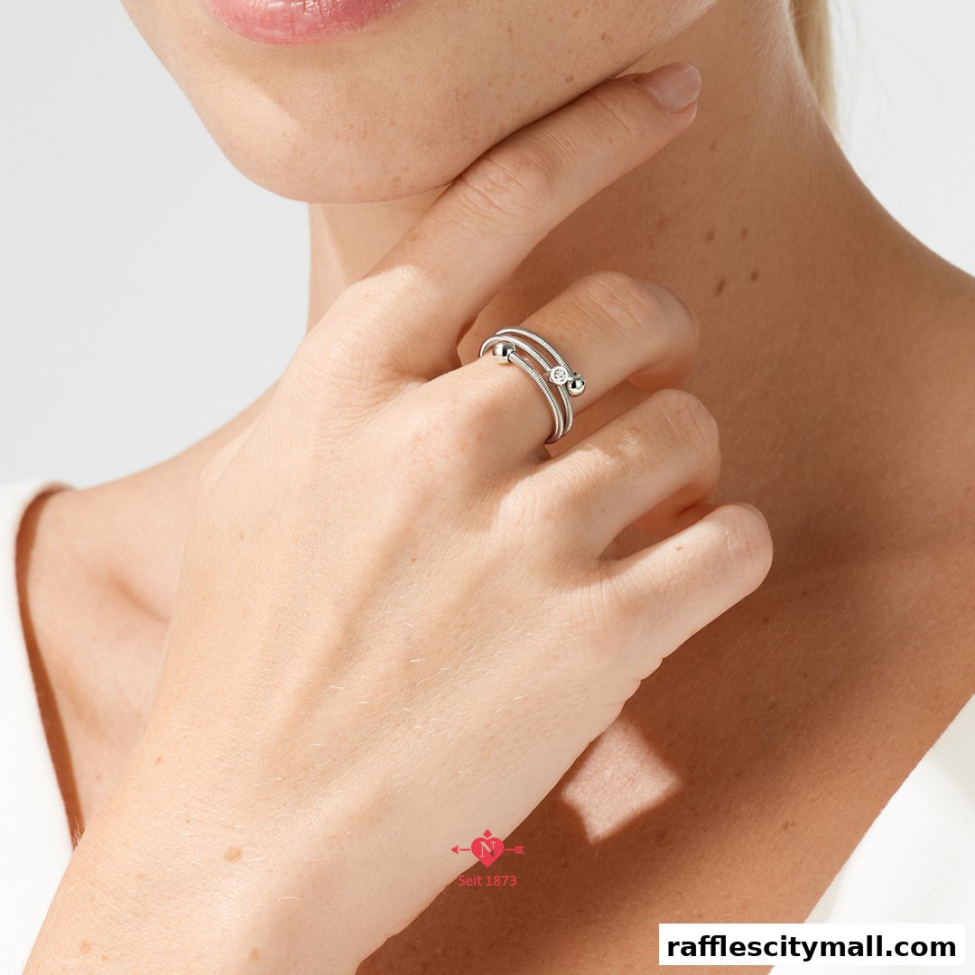 Close-up of a woman's hand wearing a delicate silver ring with a diamond.