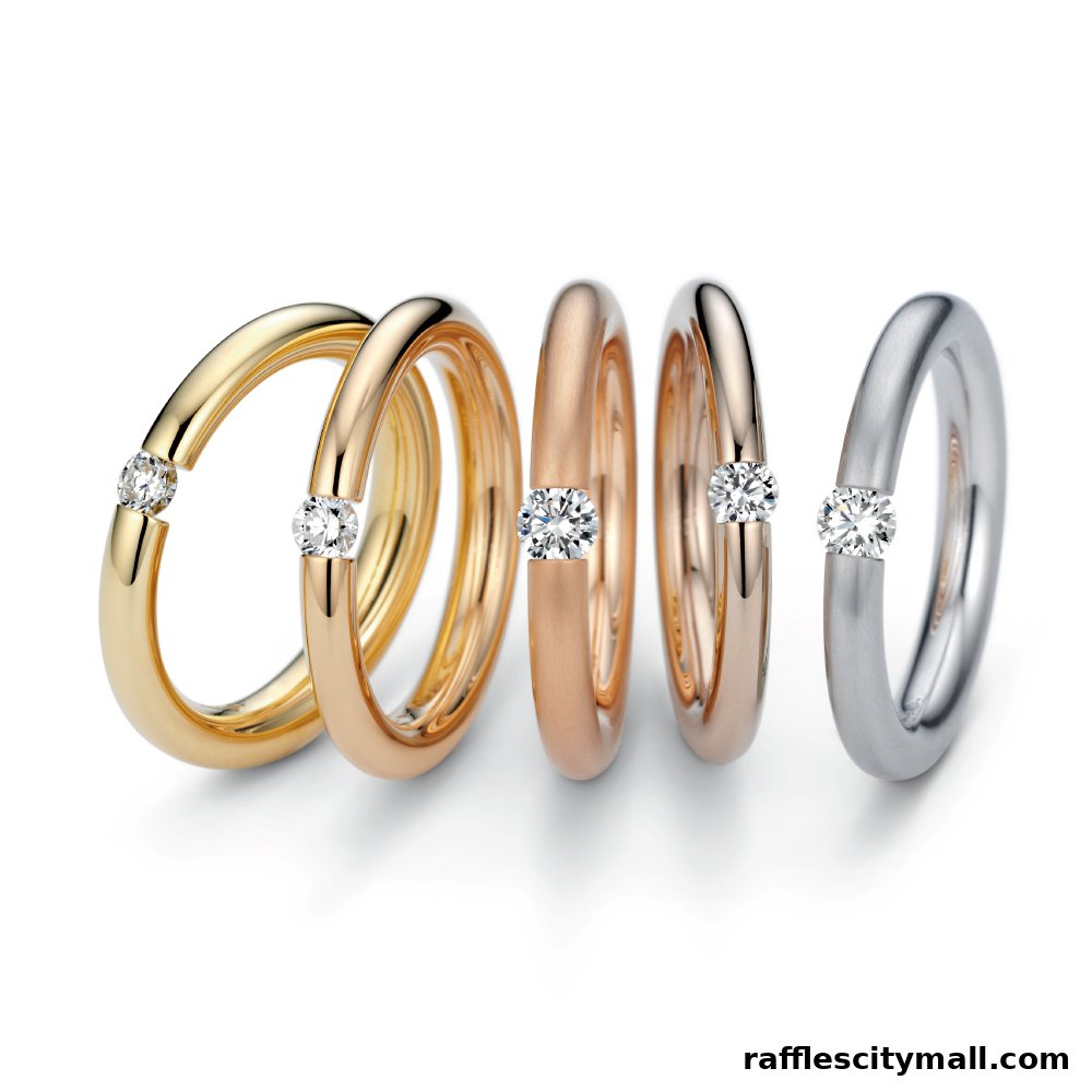 A collection of five elegant rings in different metal finishes, each with a single diamond.