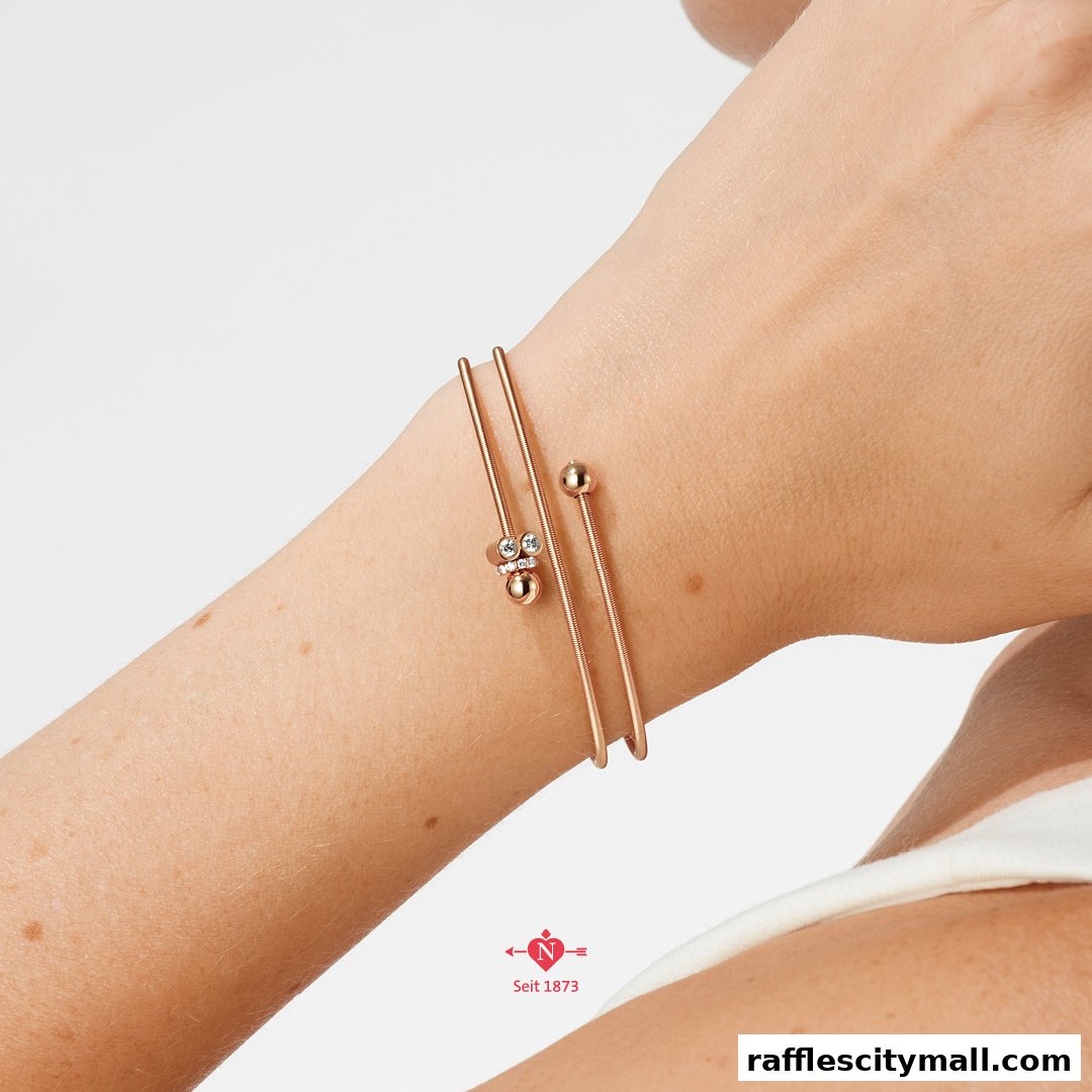 A close-up shot of a rose gold bracelet with diamonds on a person's arm.