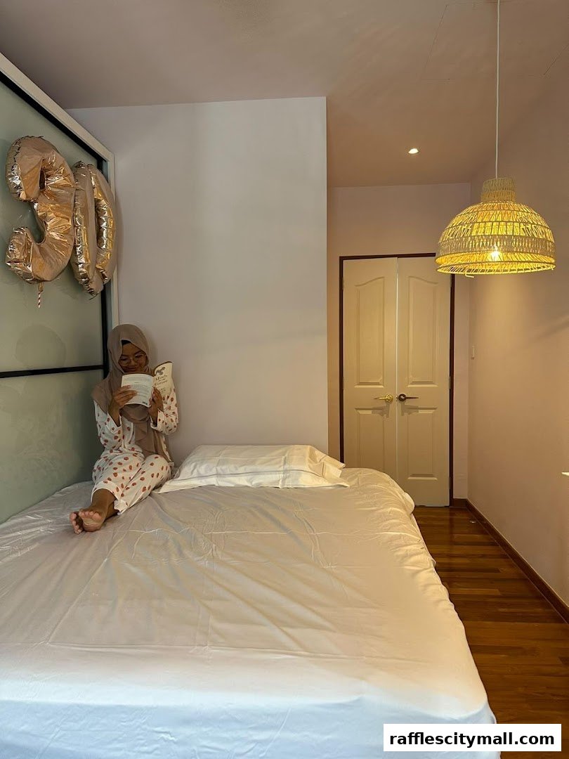 A woman in pajamas reads a book on a bed with '30' balloons nearby.