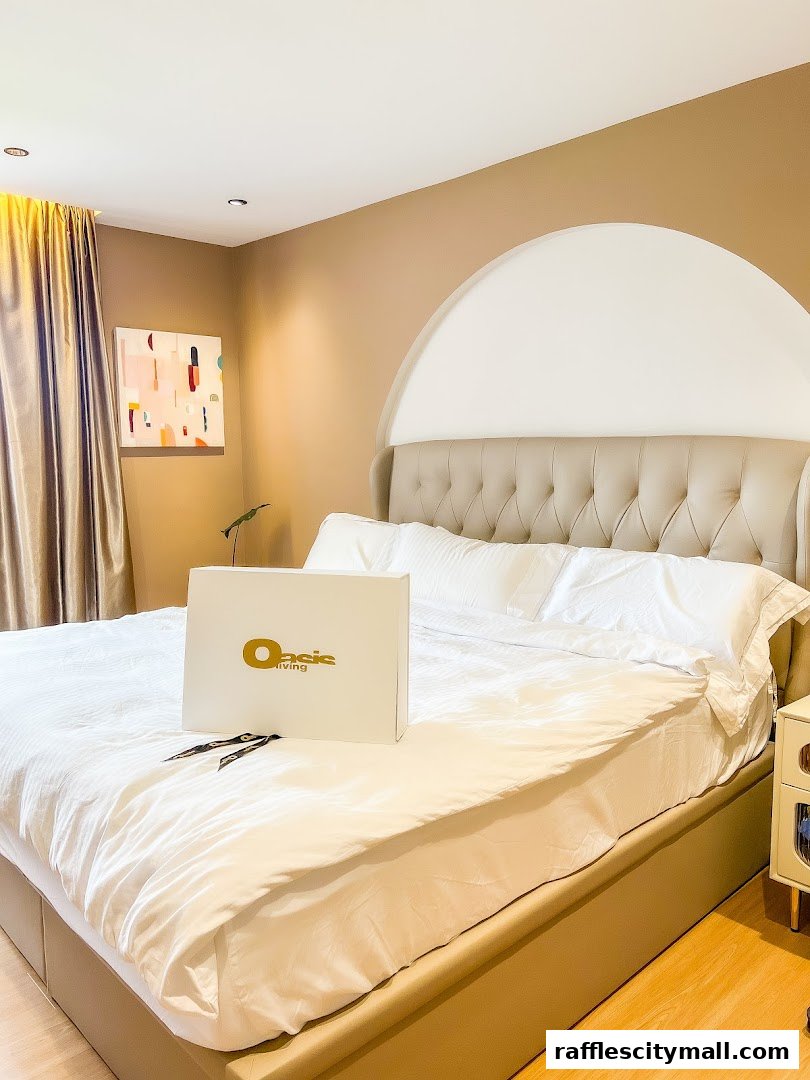 A bedroom with a bed, a box with the Oasis Living logo, and artwork on the wall.