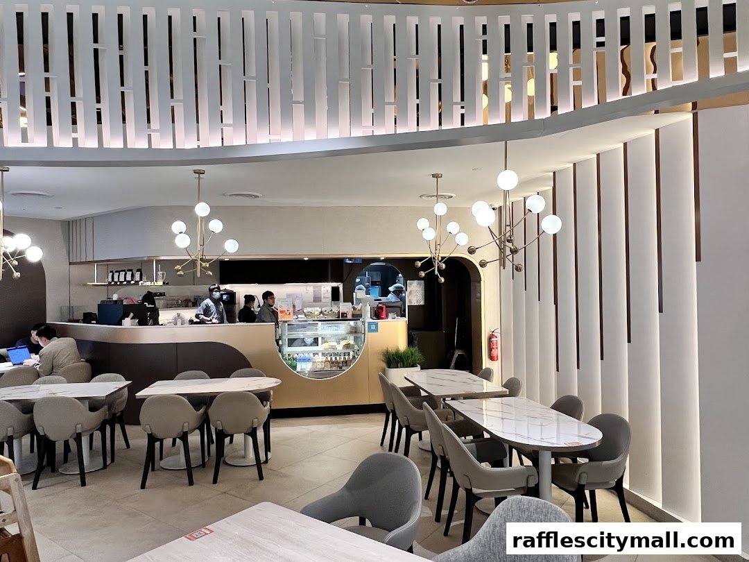 Interior of a modern cafe with tables, chairs, and a counter with staff.