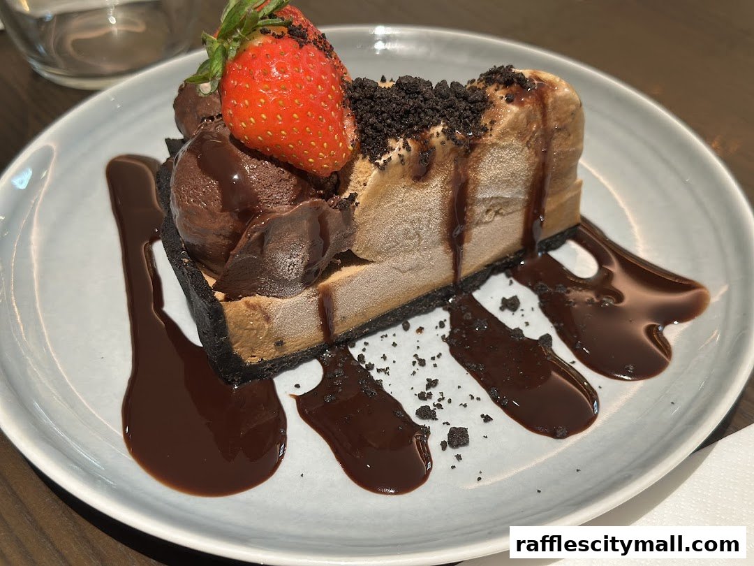 A slice of chocolate dessert with ice cream and a strawberry on top.