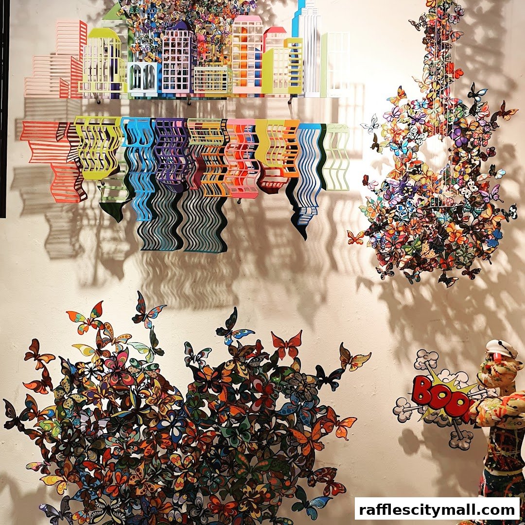 Colorful art installations featuring butterflies, cityscapes, and abstract designs on a white wall.