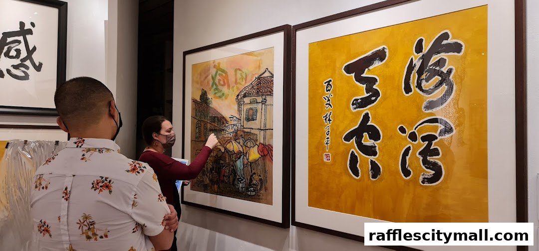 Two people are looking at framed artwork in a gallery setting.