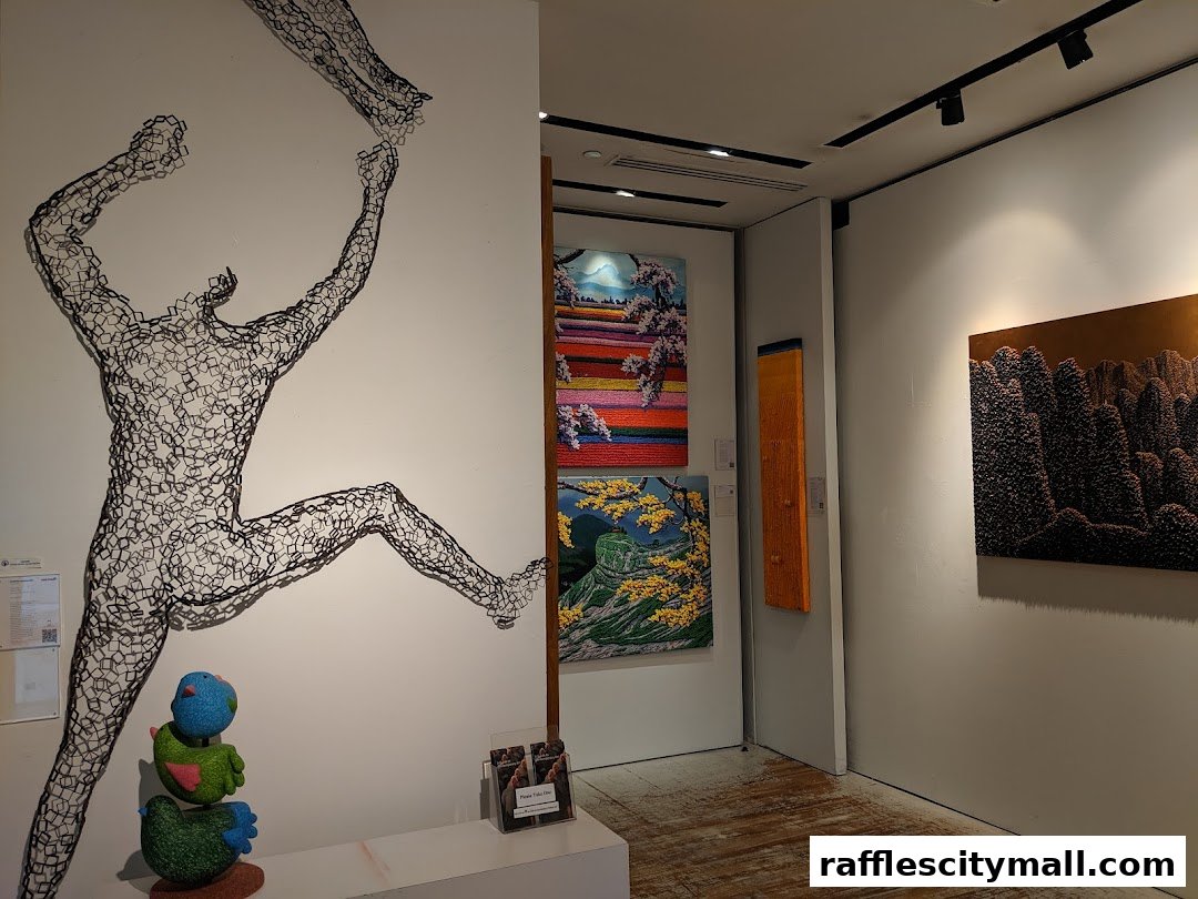 Interior view of an art gallery showcasing wire sculptures and paintings.