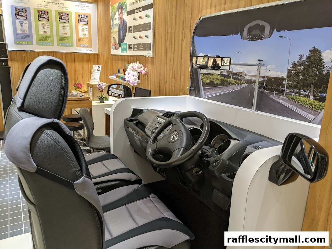 Interior view of a driving simulator with seats and a dashboard.