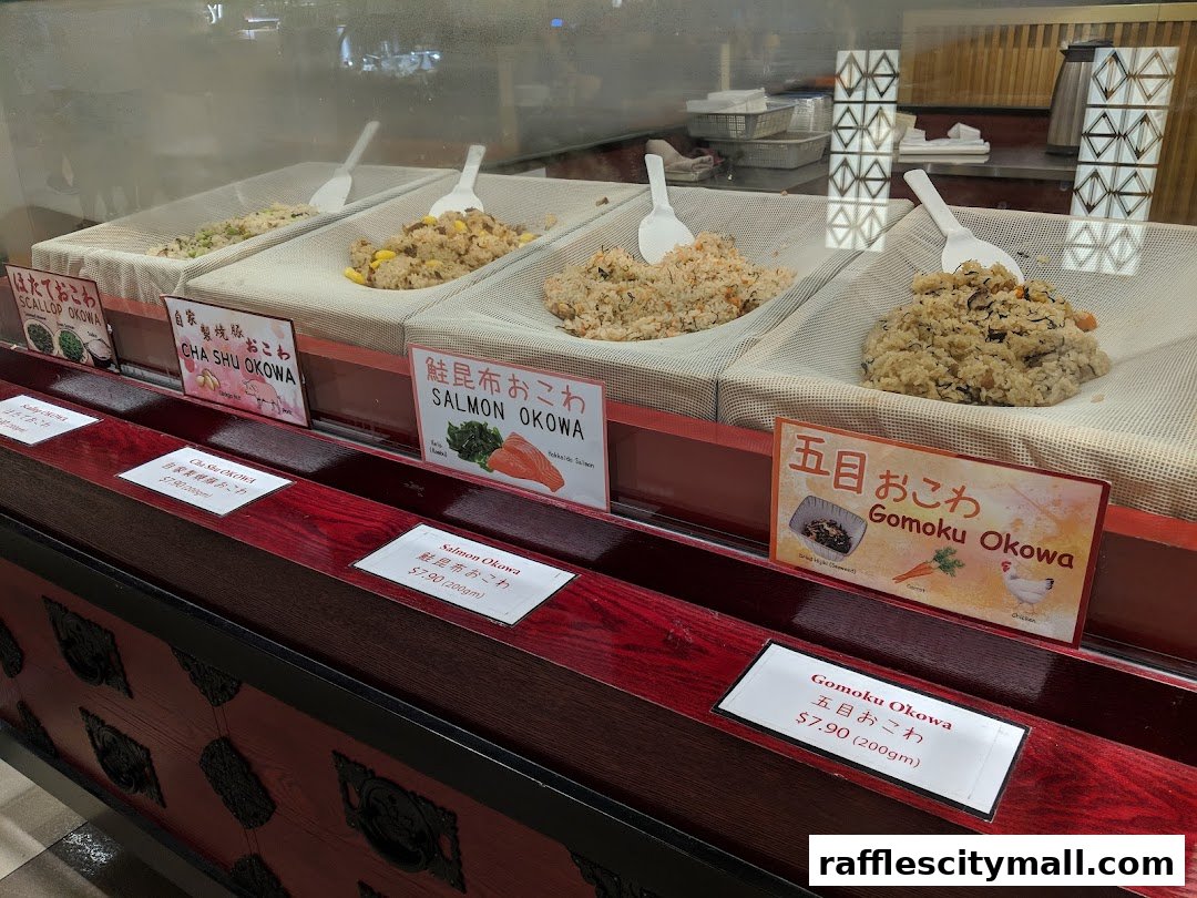 A display case showcasing various types of Japanese rice dishes, labeled with their names and prices.