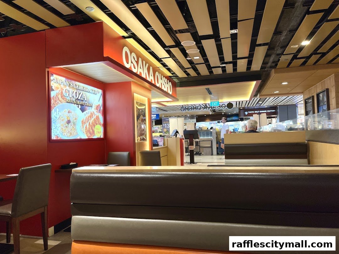 Interior view of Osaka Ohsho restaurant with seating and a glowing sign advertising Gyoza.