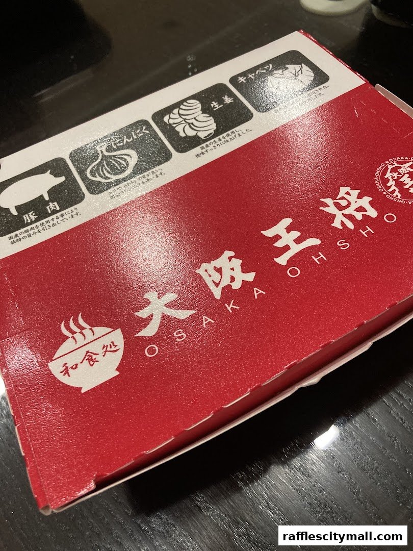 A red takeout box from Osaka Ohsho featuring ingredients like pork, garlic, ginger, and cabbage.