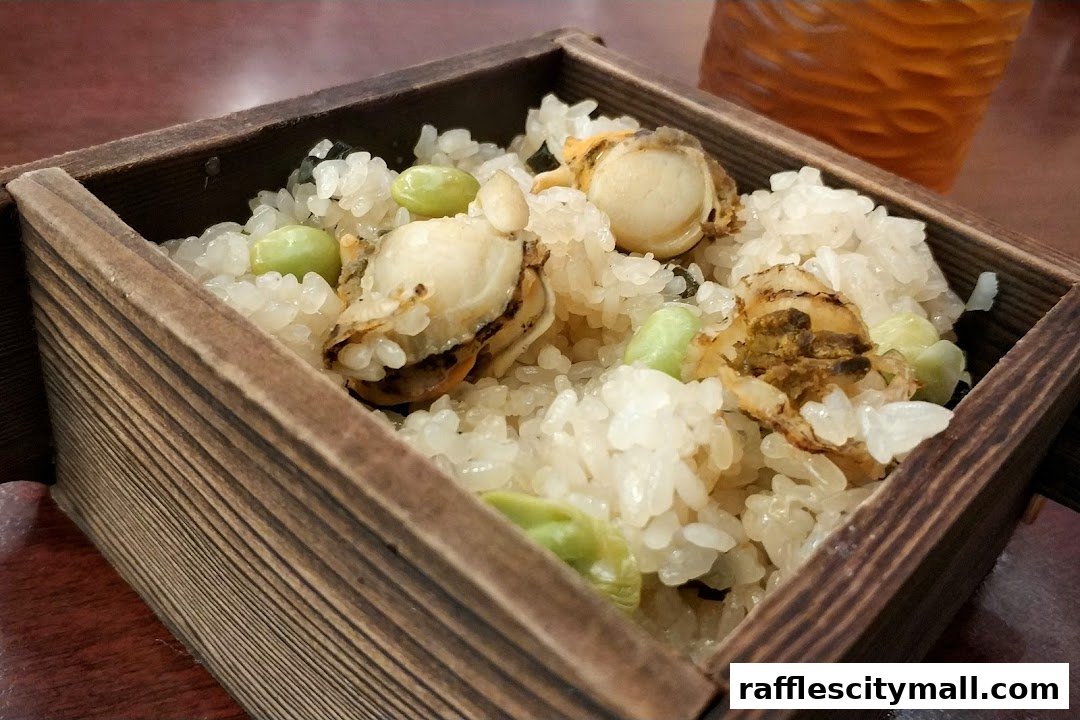 A close-up of a wooden box filled with rice, scallops, and edamame.