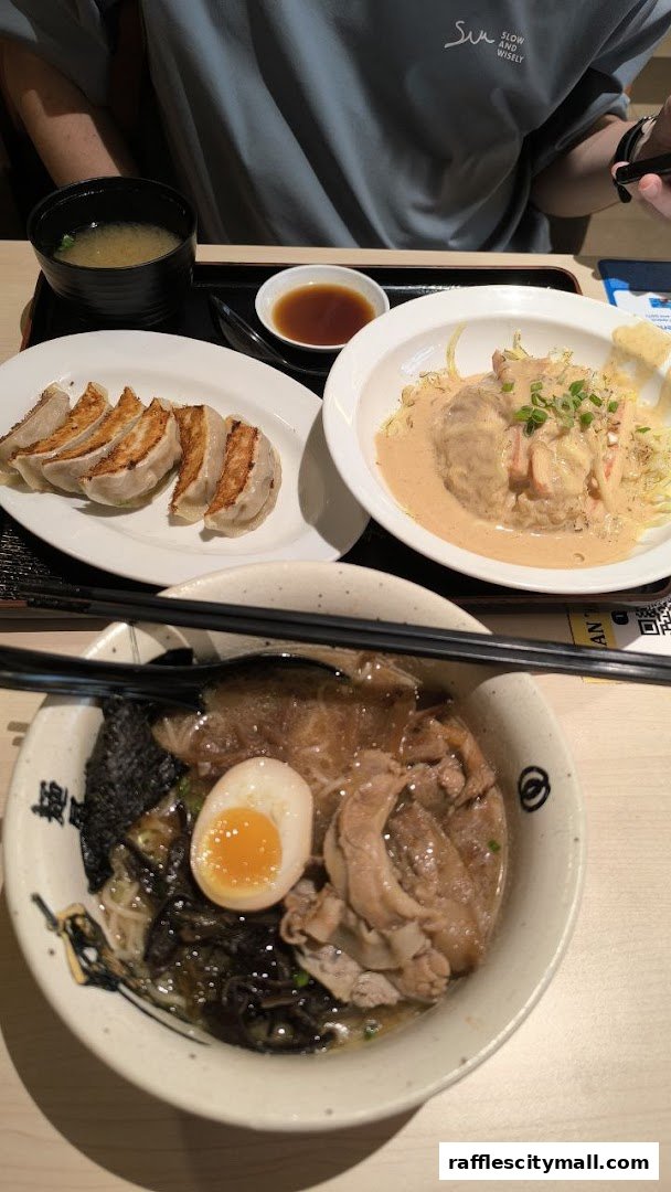 A close-up shot of a delicious Japanese meal featuring ramen, gyoza, and a side dish.