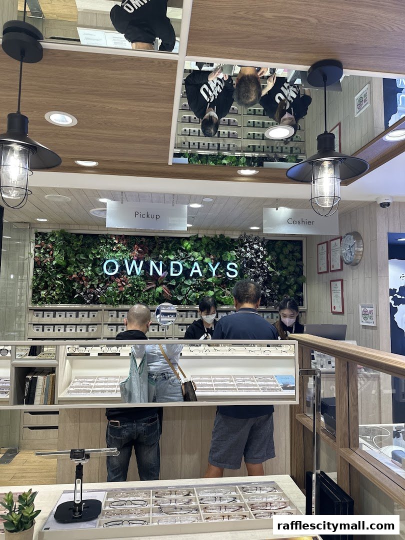 Customers at the OWNDAYS optical shop, with displays of eyeglasses and a green wall.