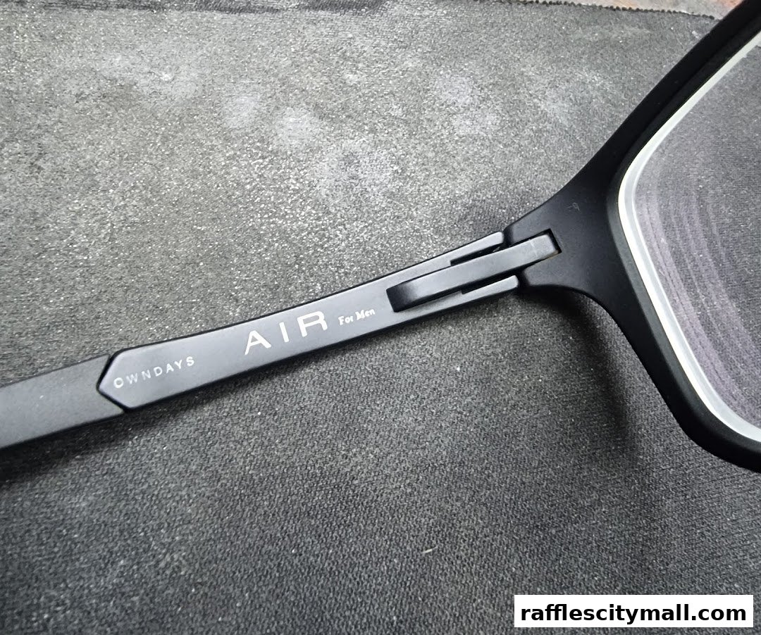 Close-up of black eyeglasses with 'OWNDAYS AIR For Men' branding on the temple.