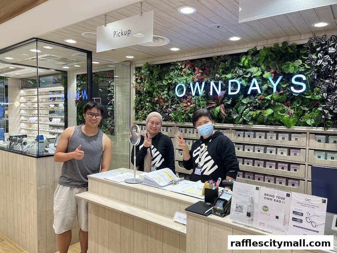 Staff and customers at the OWNDAYS optical shop counter with a green wall display.