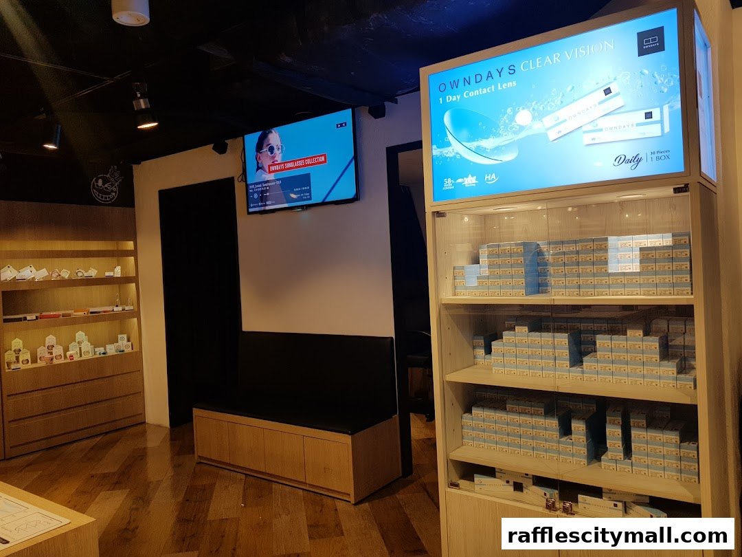 Interior of OWNDAYS Raffles City shop showcasing contact lenses and sunglasses.