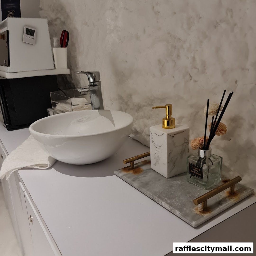A clean and modern sink area with a soap dispenser and reed diffuser.