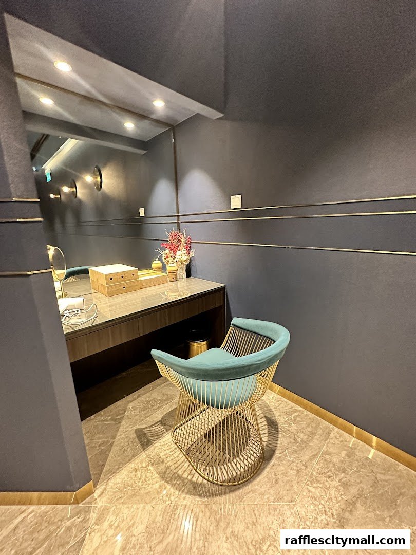 A stylish vanity area with a teal chair and a vanity table with a mirror.