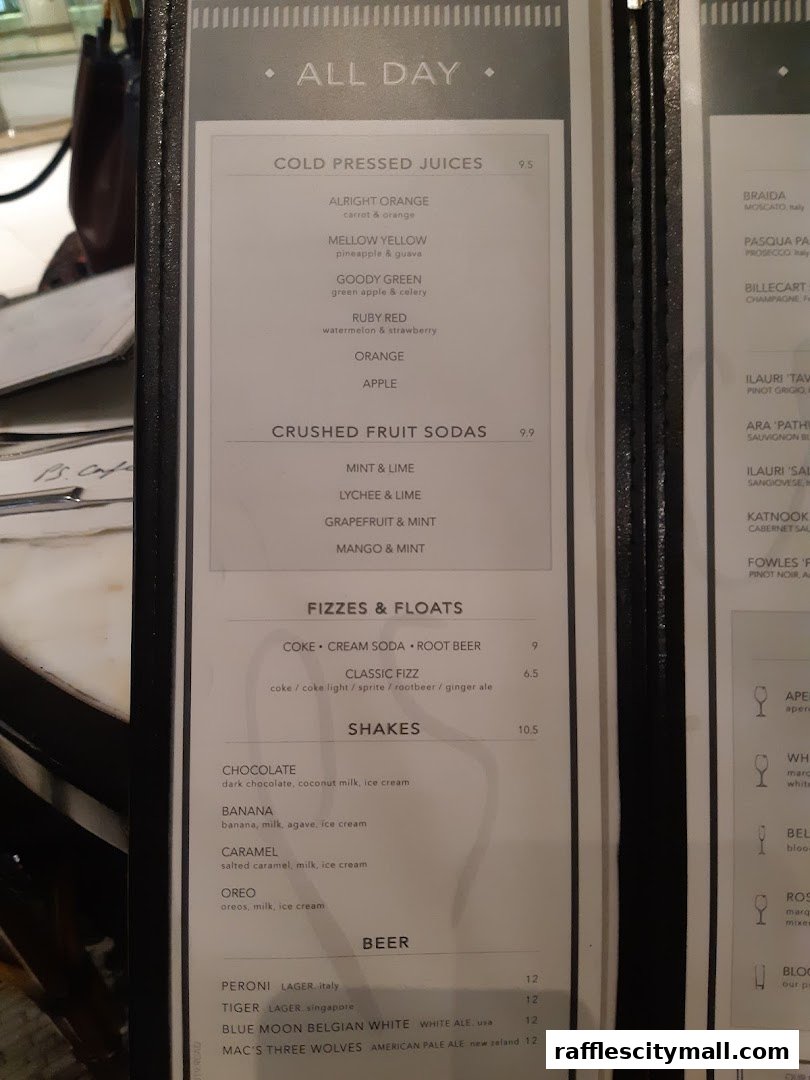 A menu from PS.Cafe Raffles City featuring juices, sodas, shakes, and beers.