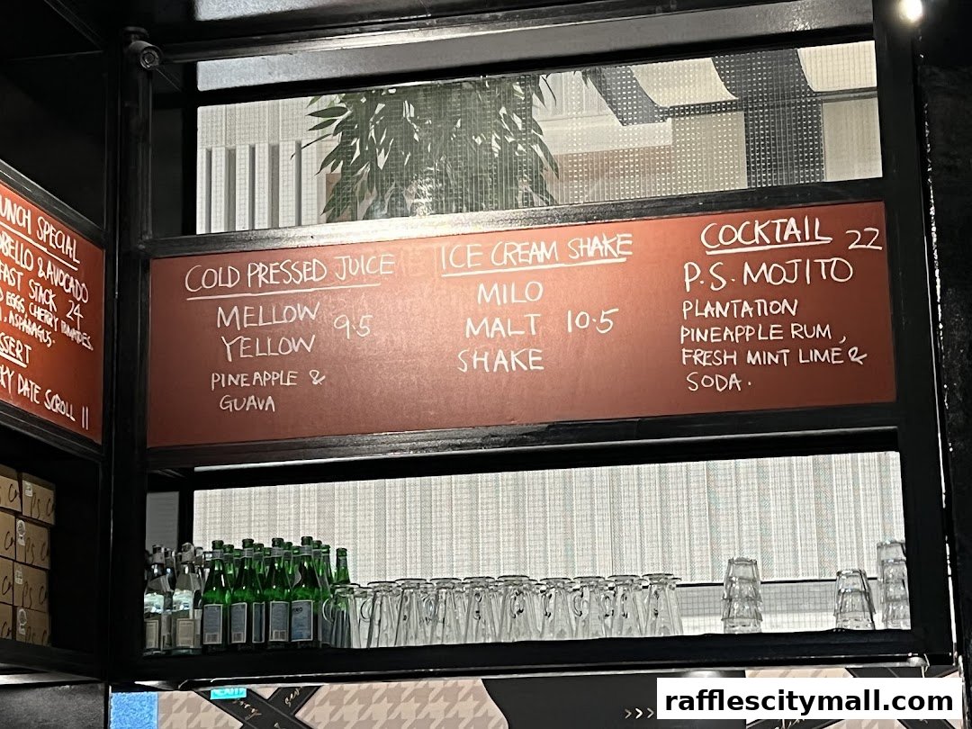 A menu board displays cold pressed juices, ice cream shakes, and cocktails with prices.