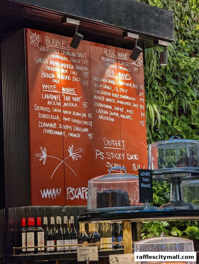 A menu board displaying wines and desserts with bottles and cakes displayed below.